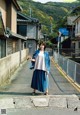 A woman standing on a sidewalk in front of a building.