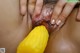 A close up of a woman's hand holding a corn on the cob.