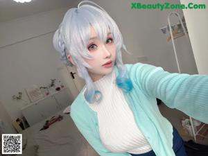 A woman with blue hair is taking a selfie.