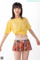 a woman in a yellow shirt and a colorful skirt