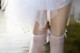 A close up of a woman's legs in white stockings.