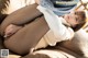 A woman in black pantyhose is sitting on a couch.