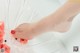 A woman's feet in a bowl of watermelon.