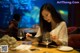 A woman sitting at a table with a tablet computer.